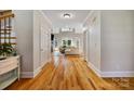 Inviting foyer with hardwood floors leading to a spacious living room featuring large windows and a fireplace at 6409 Barkley Farm Rd, Huntersville, NC 28078