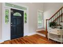Elegant foyer showcasing hardwood floors, a staircase, and a black front door with decorative glass at 6409 Barkley Farm Rd, Huntersville, NC 28078