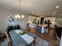 Open dining area showcasing chandelier and seamless flow into a modern kitchen at 7057 Kingfisher Way, Belmont, NC 28012