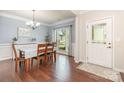 Formal dining area with hardwood floors, a chandelier, and a large window offering natural light at 8829 Keller Ct, Huntersville, NC 28078