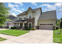 Inviting two-story home featuring stone accents, a well-manicured lawn, and an attached two-car garage at 8829 Keller Ct, Huntersville, NC 28078