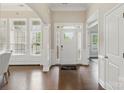 Bright foyer showcasing hardwood floors, large windows, and a welcoming entrance with an elegant welcome mat at 8830 Artesa Mill Ln, Charlotte, NC 28214