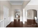 Inviting foyer with dark wood floors, elegant arches, and views into the living spaces at 8830 Artesa Mill Ln, Charlotte, NC 28214