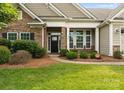 A welcoming front entrance featuring stone accents, lush landscaping, and a paved walkway at 8830 Artesa Mill Ln, Charlotte, NC 28214