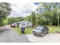 Exterior view displaying a light-colored home with a long gravel driveway at 100 Lanier St, Mount Holly, NC 28120