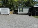 Home with a detached shed and covered carport, gravel yard, offering functional outdoor storage and parking at 102 Papoose Ct # D117, Mount Gilead, NC 27306