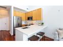 Modern kitchen with stainless steel appliances, light wood cabinets, and a breakfast bar at 115 E Park Ave # 428, Charlotte, NC 28203