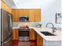 Modern kitchen featuring stainless steel appliances, wood cabinets, and a bright breakfast bar at 115 E Park Ave # 428, Charlotte, NC 28203