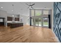 Open-concept living area with wood floors, tall ceilings, large windows, and access to the backyard at 1207 Lakedell Dr, Charlotte, NC 28215