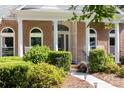Charming brick home featuring a covered front porch with arched windows and well-maintained landscaping at 122 Waterford Dr, Mooresville, NC 28117