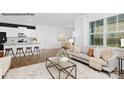 Open-concept living room with large window, sofa, and seamlessly connected to a modern kitchen and dining area at 130 Parker Claire Ln, Kings Mountain, NC 28086