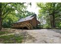 Charming home nestled in a lush, wooded area, featuring a spacious deck and a gravel driveway at 1371 Hawks Nest Rd, York, SC 29745