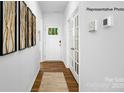 Bright hallway with hardwood floors, leading to a glass-paneled door, providing a welcoming entrance at 138 Rustling Waters Dr, Mooresville, NC 28117
