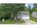 Charming two-story home showcasing neutral siding, brick accents, an attached two-car garage, and a tidy front lawn at 152 Hampshire Dr, Mooresville, NC 28115
