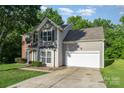 Two-story home featuring neutral siding, brick accents, and an attached two-car garage at 152 Hampshire Dr, Mooresville, NC 28115