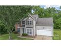Attractive two-story home featuring neutral siding, brick accents, an attached two-car garage, and landscaped front yard at 152 Hampshire Dr, Mooresville, NC 28115
