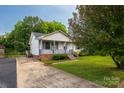 Charming home with front porch, brick foundation, manicured lawn and mature tree at 1613 Hamilton St, Charlotte, NC 28206