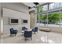 Modern lobby offers a seating area with comfortable blue chairs and decorative lighting near a large window at 210 N Church St # 2910, Charlotte, NC 28202