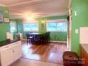 Inviting dining area featuring wood floors, bright green walls, and ample natural light from large windows at 2601 Marldale St, Gastonia, NC 28052