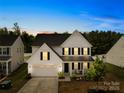 Beautiful two-story home with a two-car garage, manicured lawn and covered entryway at twilight at 3110 Streamside Dr, Davidson, NC 28036