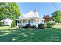 Charming home with a landscaped lawn and front porch offers a blend of comfort and curb appeal on a sunny day at 328 E Center Ave, Mooresville, NC 28115
