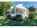 Charming home featuring a landscaped lawn, manicured bushes and inviting front porch, perfect for enjoying a peaceful setting at 328 E Center Ave, Mooresville, NC 28115