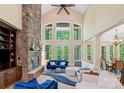 Bright living room featuring a stone fireplace and large windows with backyard views at 335 Whisper Lake Dr, New London, NC 28127