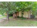 A charming bungalow-style home with a brick and siding exterior and mature trees at 3924 Tillman Rd, Charlotte, NC 28208