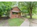 A single story home with a brick and siding exterior and mature trees in the front yard at 3924 Tillman Rd, Charlotte, NC 28208
