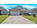 Charming single-story home with a two car garage and a well-manicured front yard under a blue sky at 4243 Merrivale Dr, Lancaster, SC 29720
