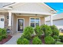 Inviting covered front porch with stone accents and lush landscaping creating a warm and welcoming entrance at 4243 Merrivale Dr, Lancaster, SC 29720