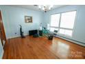 Sunny dining room with hardwood floors, large window, and classic chandelier fixture at 4268 Wilkesboro Hwy, Statesville, NC 28625