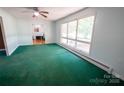 Bright living room with large windows, green carpet, and neutral walls at 4268 Wilkesboro Hwy, Statesville, NC 28625