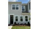 Close up of townhome featuring gray siding, white trim, a black door, and well-placed shrubbery at 4706 Lakeview Rd # 9, Charlotte, NC 28216