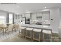 Kitchen with gray island, white cabinetry, stainless appliances, and dining table at 5030 Grain Orchard Rd # 3025C, Indian Trail, NC 28079
