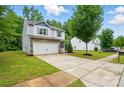 A well-manicured lawn and a paved driveway lead up to this beautiful two-story home at 6322 Sydney Mae Ln, Charlotte, NC 28262