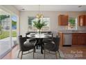 Cozy dining area with views of the backyard, contemporary chandelier, and seating for four at 6332 Sackett Way, Charlotte, NC 28269