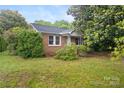 Charming brick home with a covered front porch, complemented by mature trees and landscaping at 653 Turner St, Mooresville, NC 28115