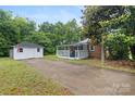Home featuring a storage building, an extended driveway, and a covered back porch with white railings at 653 Turner St, Mooresville, NC 28115