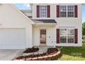 Close up of the home's entrance, featuring a well maintained lawn and brick landscaping accents at 7212 Ravanna Dr, Charlotte, NC 28213