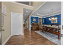 Open-concept dining room with hardwood floors, blue accent wall and coffered ceilings at 10206 Linksland Dr, Huntersville, NC 28078