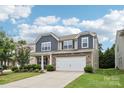 Charming two-story home with stone accents, neutral siding, a well-manicured lawn, and a two-car garage at 107 Sequoia St, Mooresville, NC 28117