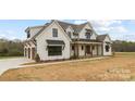 Charming two-story farmhouse with a three car garage, black window accents and well manicured landscaping at 111 Monbo Meadows Ln, Statesville, NC 28677