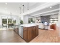 Island kitchen with wood accents, stainless steel appliances, pendant lights, and an open view to the living and dining areas at 111 Monbo Meadows Ln, Statesville, NC 28677