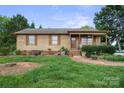 Traditional home featuring a covered porch, well-manicured lawn and mature trees at 112 Gays Chapel Rd, Statesville, NC 28625