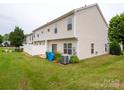 Property featuring a fenced backyard, complemented by green grass and a visible air conditioning unit at 12222 Stratfield Place Cir, Pineville, NC 28134
