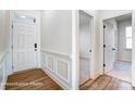 Elegant foyer with white wainscoting, hardwood floors, and access to multiple rooms at 123 Prestwick Way # 42, Mooresville, NC 28115