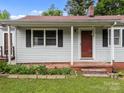 A tidy single-story home has a quaint porch entry with a neat garden bed lining the foundation at 1333 Washington Ln, Kannapolis, NC 28083