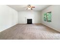Bright living room featuring a fireplace, plush carpeting, and a large window overlooking the yard at 178 Wellshire St, Mooresville, NC 28115
