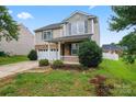 Inviting two-story house with a stone-accented front, attached garage, and a lush green lawn on a sunny day at 1911 Savannah Hills Dr, Matthews, NC 28105